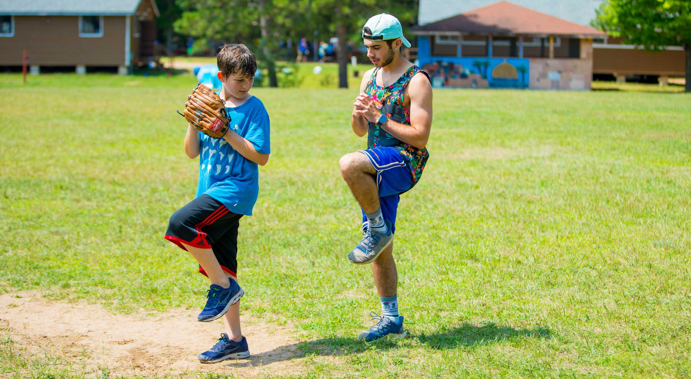 Baseball instructor teaching camper how to throw