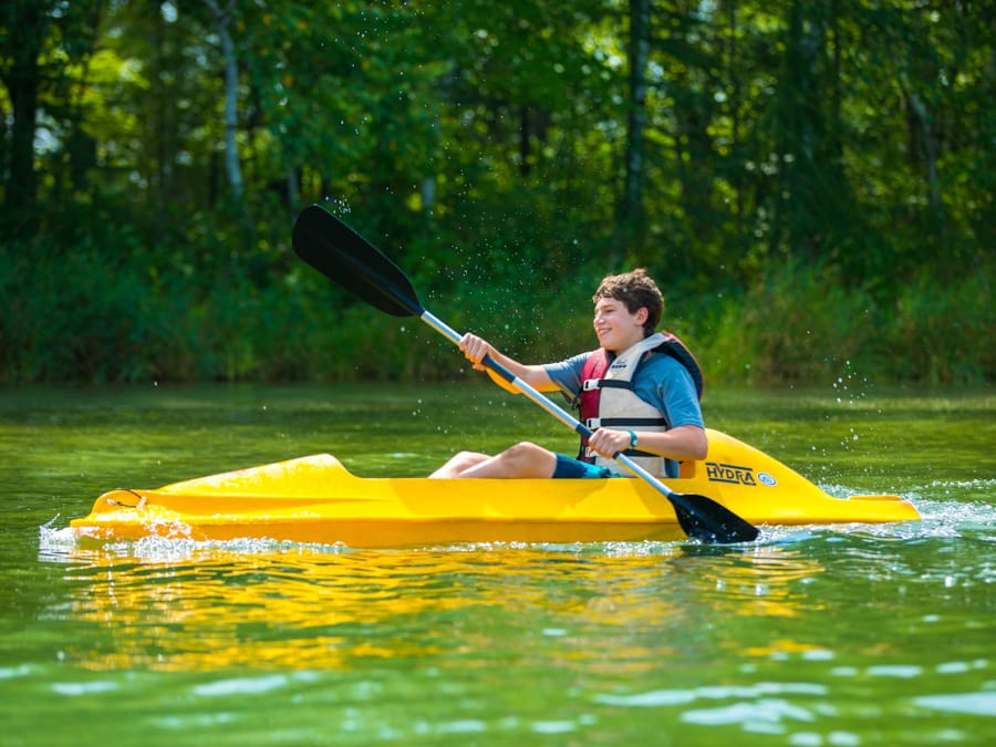 Boy in yellow kayak on lake
