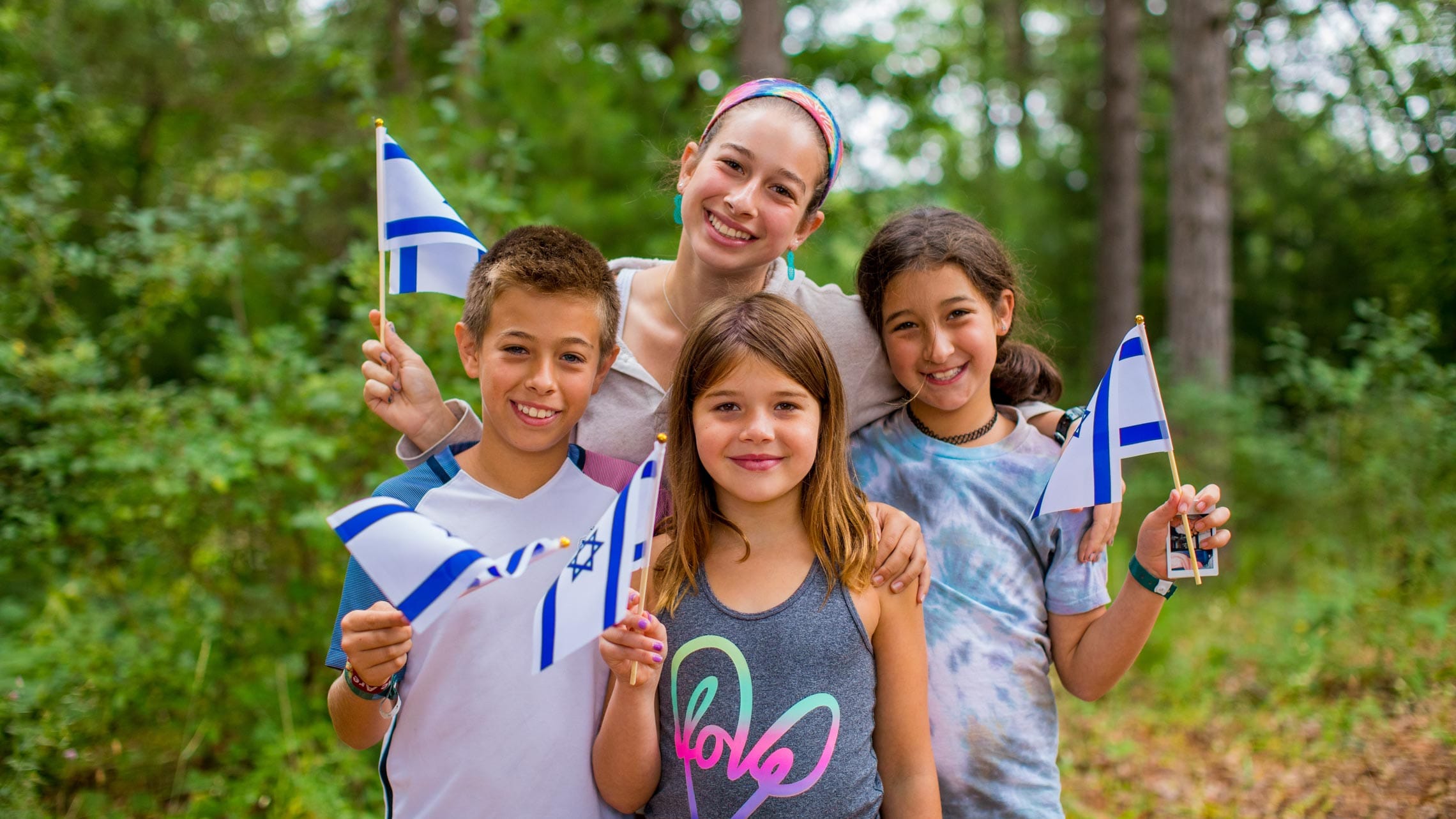 Staff and three campers with Israeli flags