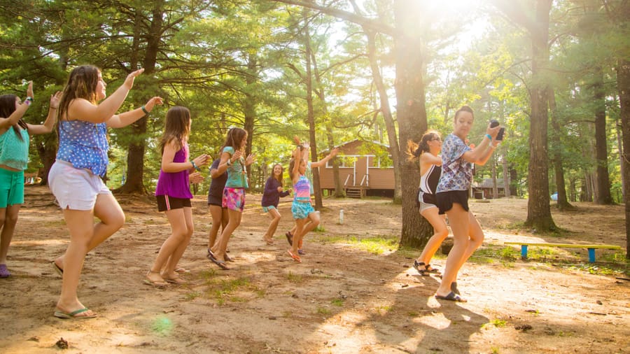 Female campers taking a dance class outdoors