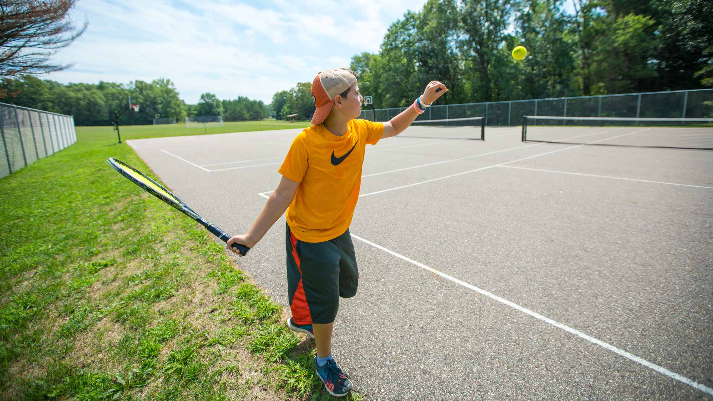 Boy serving at tennis